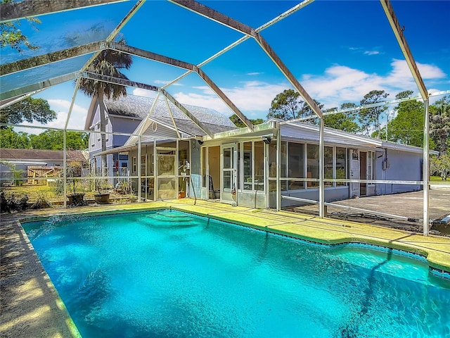 pool with a sunroom, a lanai, and a patio area