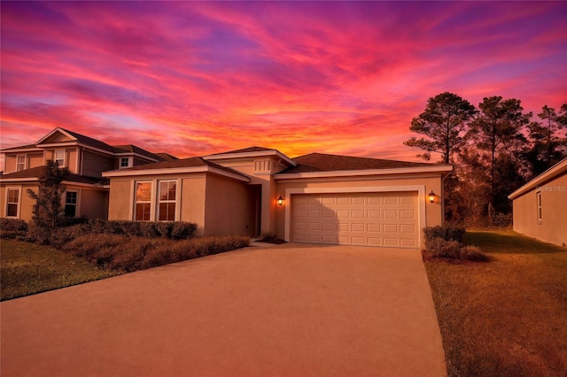 prairie-style home featuring a garage, stucco siding, and concrete driveway