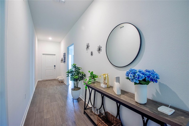 corridor with baseboards and wood finished floors