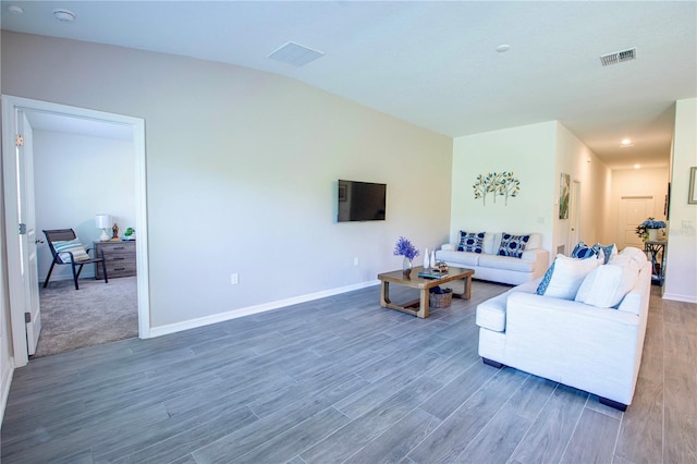 living room featuring visible vents, baseboards, and wood finished floors