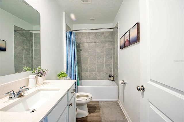 bathroom featuring vanity, shower / tub combo with curtain, visible vents, toilet, and a textured ceiling