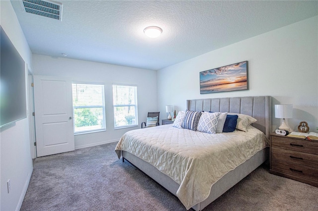 bedroom with visible vents, carpet flooring, a textured ceiling, and baseboards