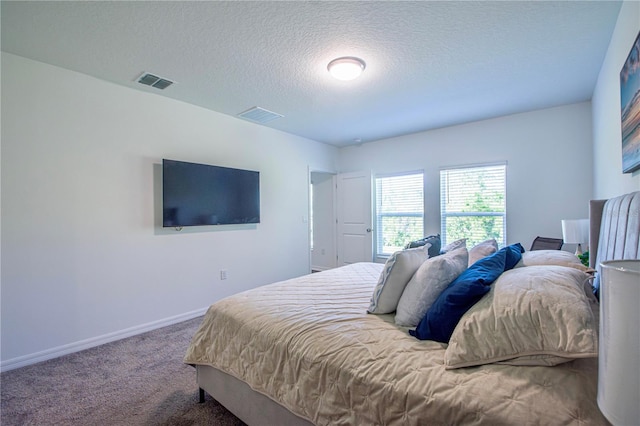 carpeted bedroom featuring visible vents, a textured ceiling, and baseboards