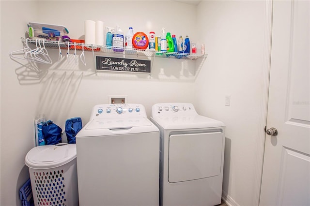 clothes washing area featuring separate washer and dryer and laundry area