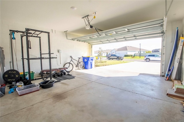 garage featuring a garage door opener and concrete block wall