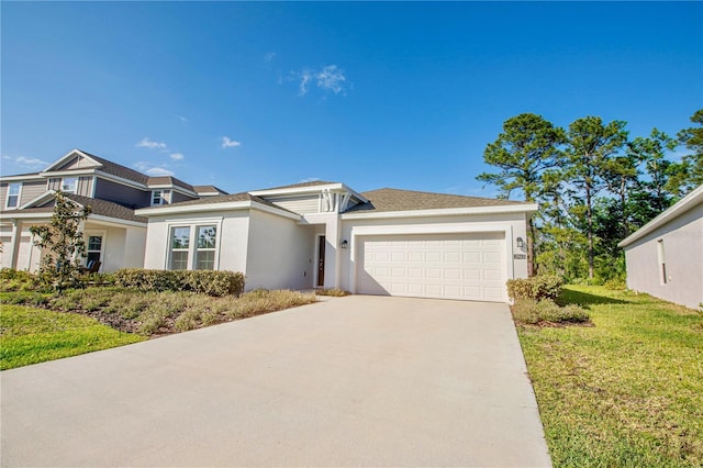 prairie-style home featuring roof with shingles, a front lawn, concrete driveway, an attached garage, and stucco siding