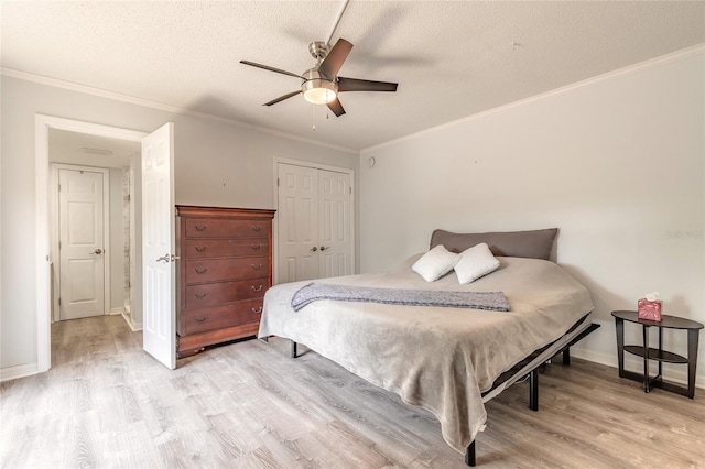 bedroom featuring light wood finished floors, a textured ceiling, crown molding, a closet, and ceiling fan