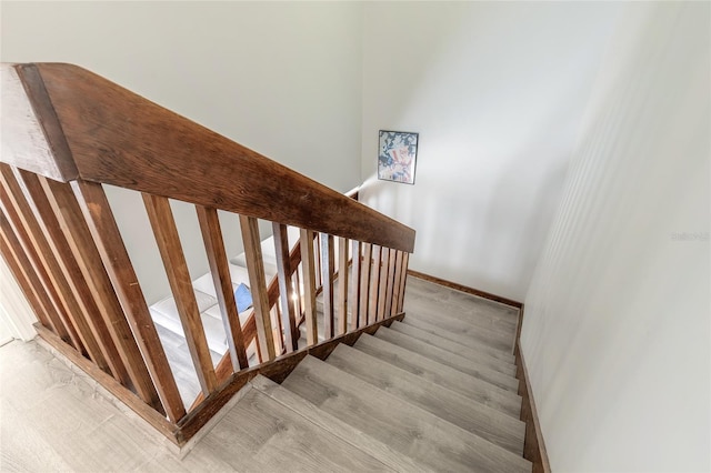 stairway featuring wood finished floors and baseboards