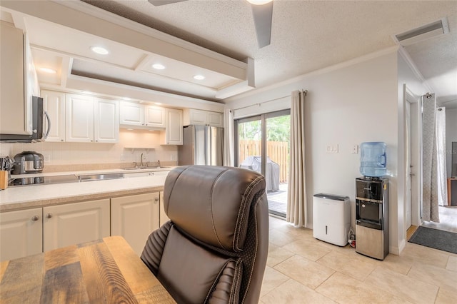 kitchen with freestanding refrigerator, ornamental molding, light countertops, white cabinetry, and a ceiling fan