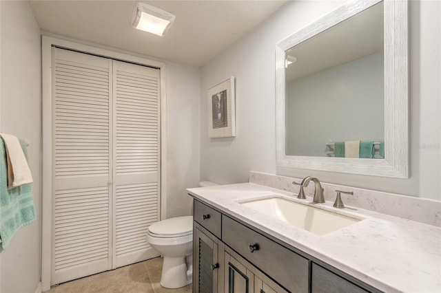 bathroom with toilet, a closet, and vanity