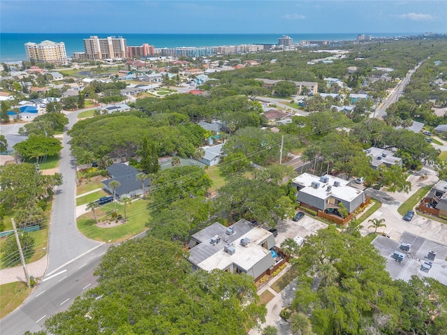 aerial view of property and surrounding area with a nearby body of water and nearby urban area