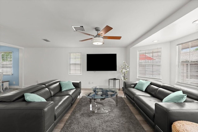 living room with baseboards, ceiling fan, wood finished floors, and visible vents
