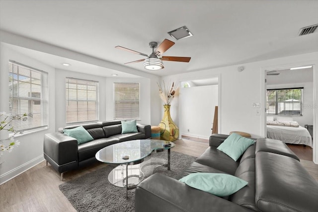 living room featuring ceiling fan, recessed lighting, baseboards, wood finished floors, and visible vents