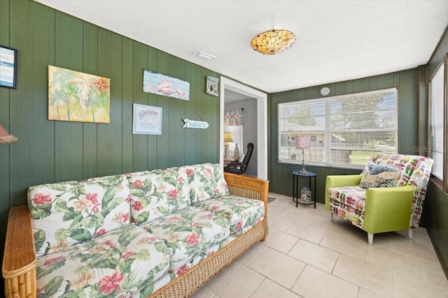 living room featuring tile patterned flooring and wood walls