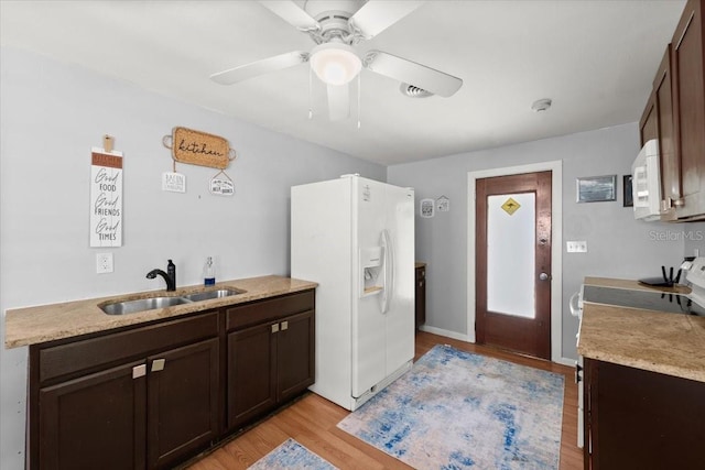 kitchen with a sink, a ceiling fan, dark brown cabinetry, and white appliances