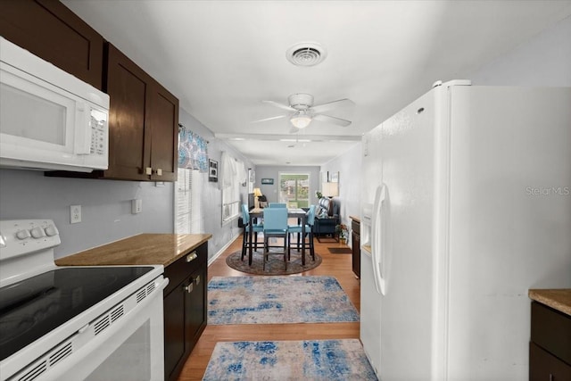kitchen featuring dark brown cabinetry, ceiling fan, light wood-style floors, white appliances, and visible vents