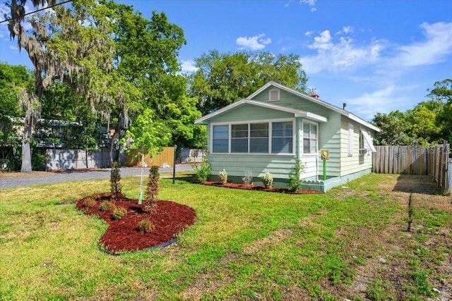 view of front facade featuring a fenced backyard and a front lawn