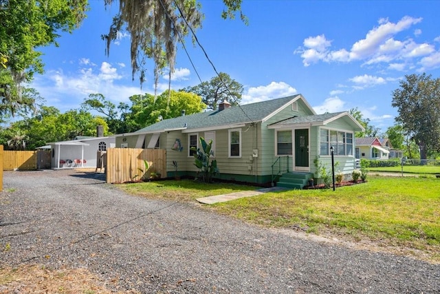 ranch-style home featuring fence, driveway, a chimney, and entry steps