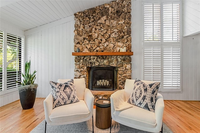 sitting room featuring a wealth of natural light, wooden walls, and wood finished floors