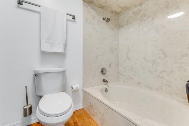 full bathroom featuring toilet, bathing tub / shower combination, wood finished floors, and baseboards