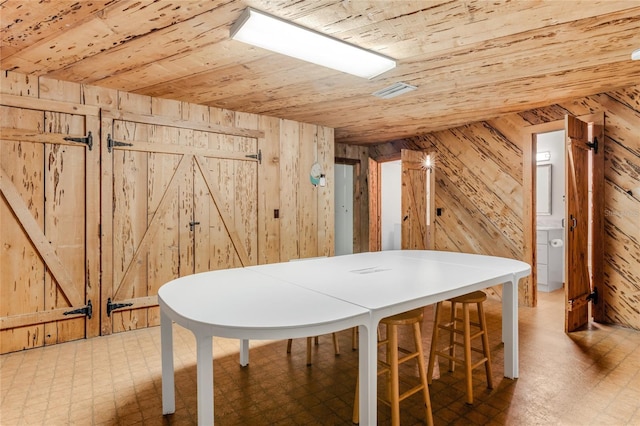 additional living space with tile patterned floors, wood walls, wooden ceiling, and visible vents