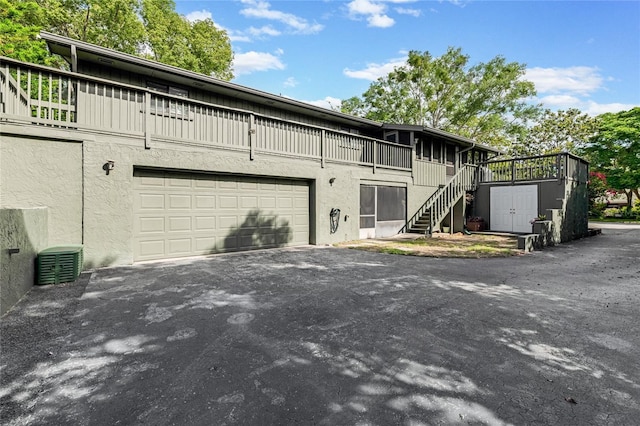 view of front of house with driveway, stucco siding, stairway, and an attached garage