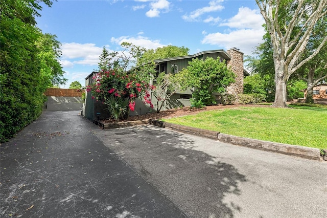 view of front facade with a chimney and a front yard