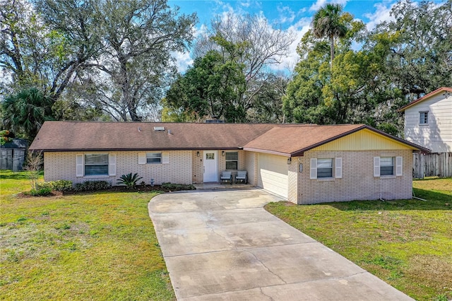 single story home with concrete driveway, a garage, a front lawn, and brick siding