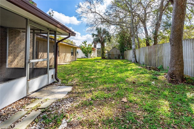 view of yard featuring fence and a sunroom