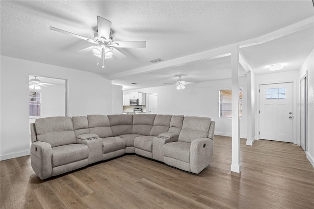 living area featuring baseboards, ceiling fan, and wood finished floors