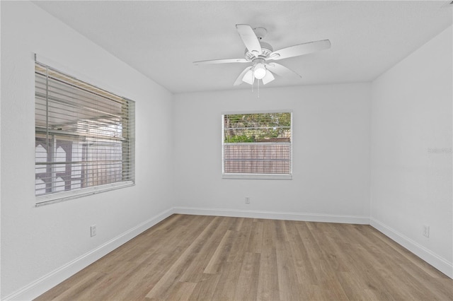 empty room with baseboards, a ceiling fan, and wood finished floors