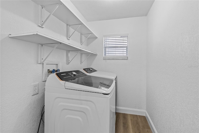 laundry area with separate washer and dryer, laundry area, dark wood finished floors, and baseboards