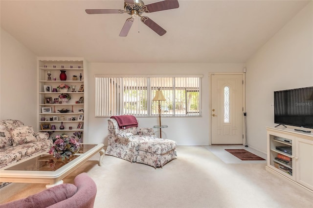 carpeted living area with a ceiling fan