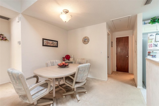 dining area featuring attic access, light colored carpet, and baseboards