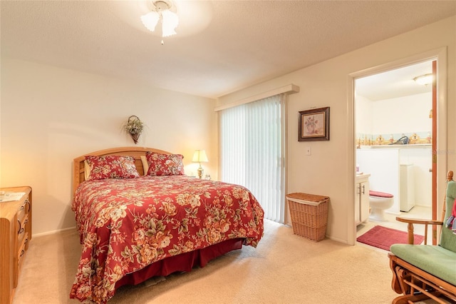 carpeted bedroom with ensuite bathroom, a ceiling fan, and a textured ceiling