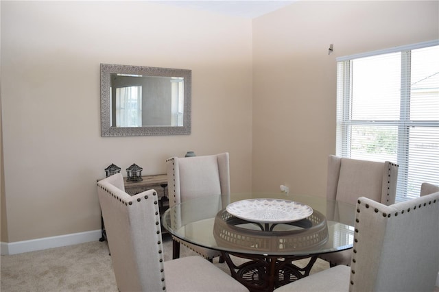 carpeted dining area featuring baseboards