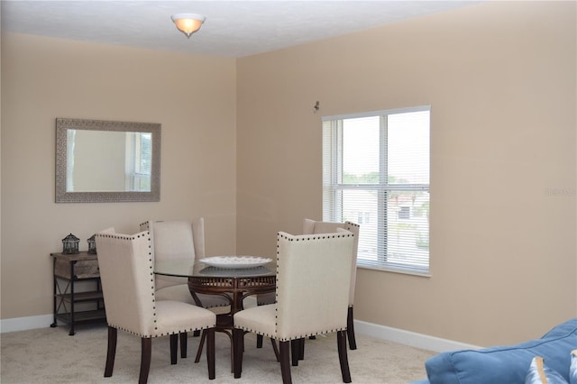 carpeted dining space with baseboards and a healthy amount of sunlight