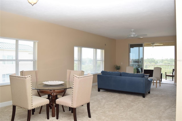 dining area with light carpet, baseboards, and a ceiling fan