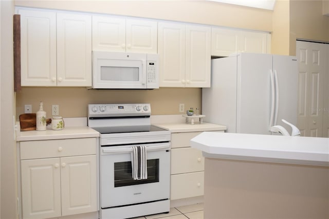 kitchen with white appliances, light countertops, light tile patterned floors, and white cabinets