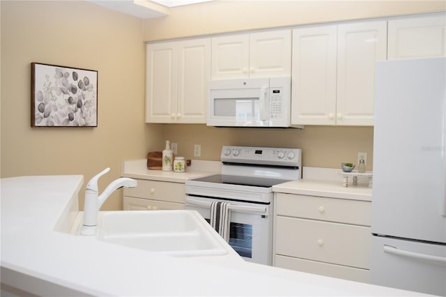 kitchen with white cabinets, light countertops, a sink, and white appliances