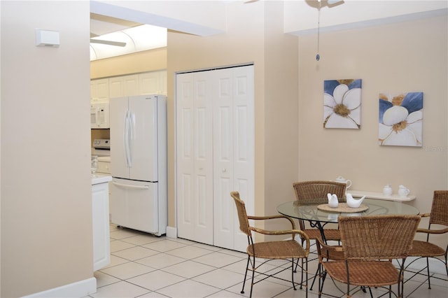 dining area with light tile patterned floors, baseboards, and ceiling fan