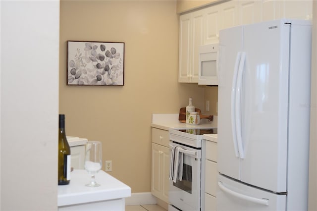 kitchen with baseboards, light tile patterned floors, white appliances, white cabinetry, and light countertops