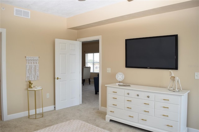 bedroom featuring visible vents, baseboards, and light carpet