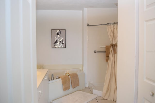 bathroom with tile patterned floors, vanity, a stall shower, and a garden tub