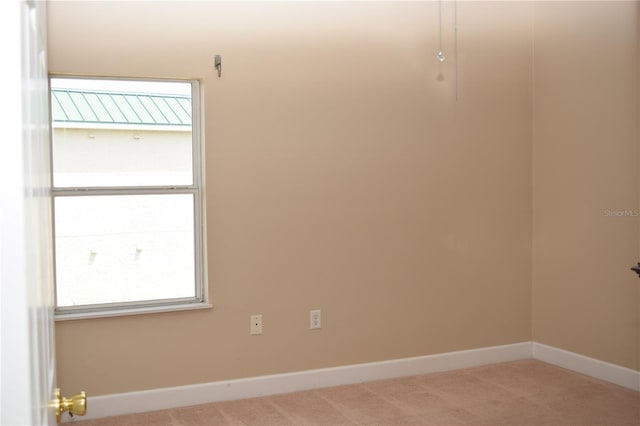 unfurnished room featuring carpet floors and baseboards