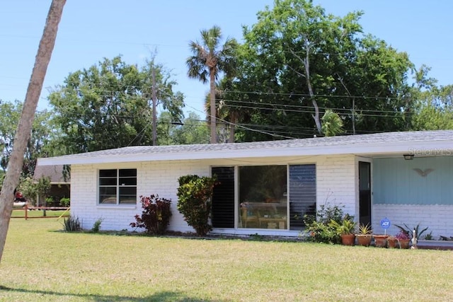 1830 Needle Palm Dr, Edgewater, FL 32132 - back of house with brick siding and a yard