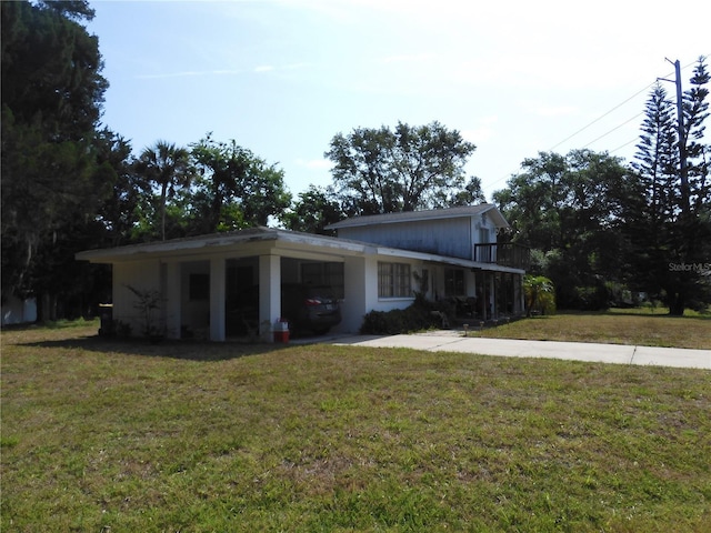 view of front of property featuring a carport, a front lawn, and concrete driveway