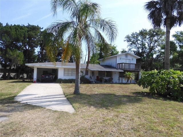 view of front of house with concrete driveway, a front yard, a balcony, and a carport