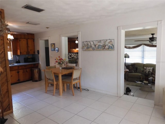 dining area featuring a ceiling fan and light tile patterned floors