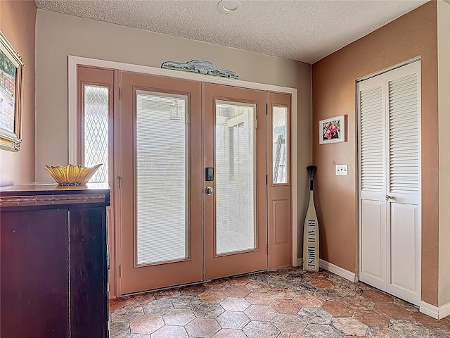 31 Sea Harbor Dr E, Ormond Beach, FL 32176 - doorway to outside with french doors, a textured ceiling, and baseboards